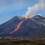 L'Etna in eruzione con una colata lavica visibile sul versante.