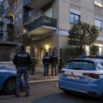 Polizia davanti a un palazzo di periferia a Roma, con area transennata.