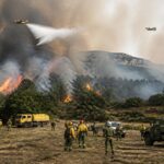 Incendio boschivo in Aragona con fumo denso, squadre di emergenza e mezzi aerei in azione.