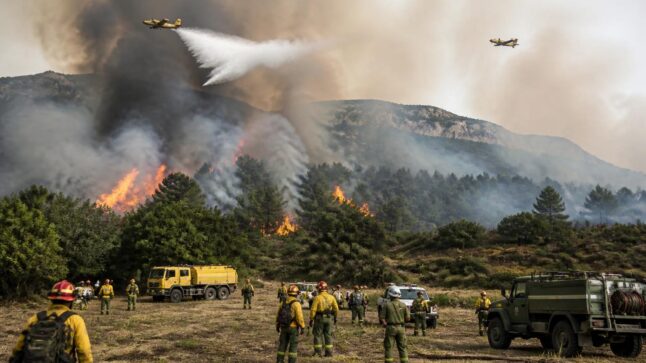 Incendio boschivo in Aragona con fumo denso, squadre di emergenza e mezzi aerei in azione.