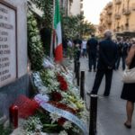 Commemorazione della strage di via D'Amelio con fiori e candele davanti a un memoriale a Palermo.