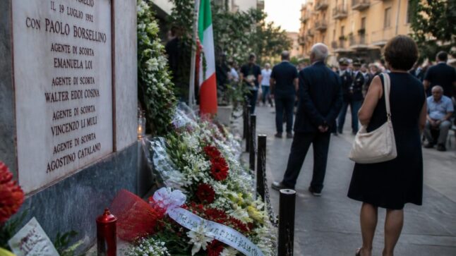 Commemorazione della strage di via D'Amelio con fiori e candele davanti a un memoriale a Palermo.