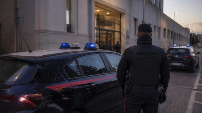 Carabinieri italiani durante un’operazione antimafia all’alba davanti a un edificio giudiziario.