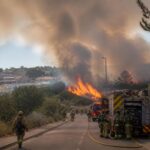 Incendio boschivo nella regione di Madrid con fumo, fiamme e mezzi di soccorso.